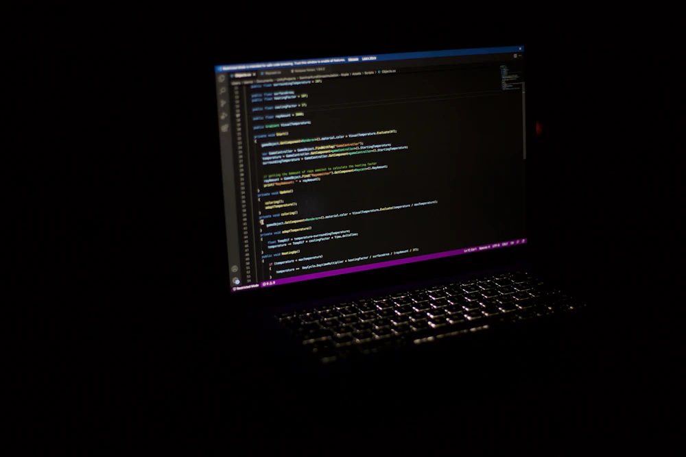 Ordenador portátil con un entorno de programación en una habitación oscura